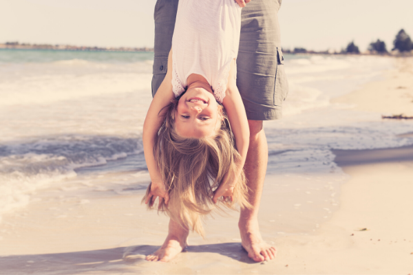 Girl and father playing at beach